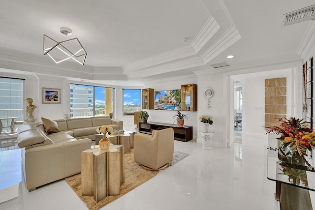 living room with ornamental molding, a tray ceiling, and a chandelier