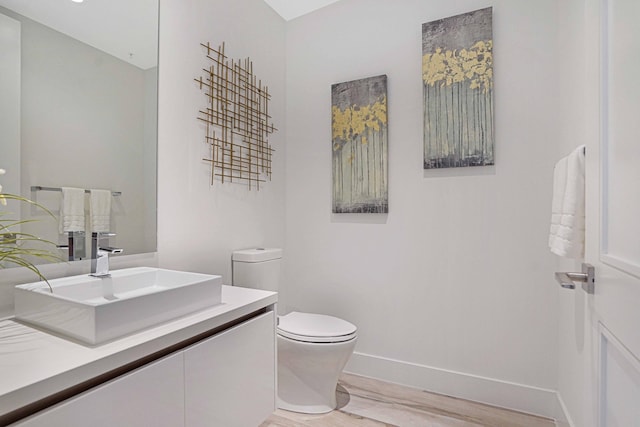 bathroom featuring hardwood / wood-style floors, vanity, and toilet