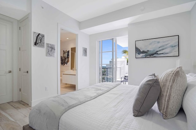 bedroom featuring access to exterior, light hardwood / wood-style flooring, and ensuite bath