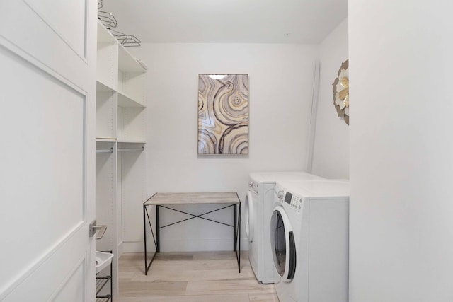 laundry room with light wood-type flooring and separate washer and dryer