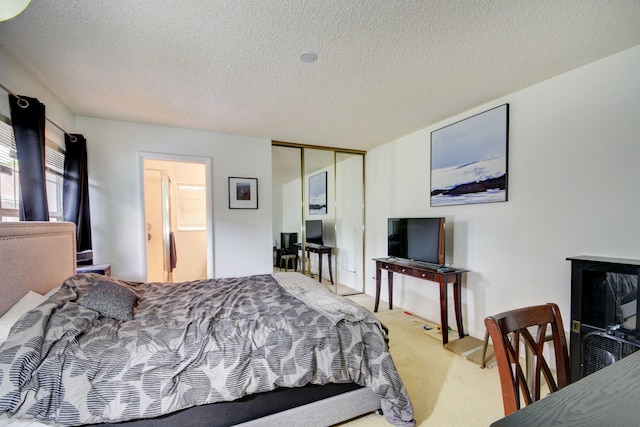 carpeted bedroom featuring a closet and a textured ceiling