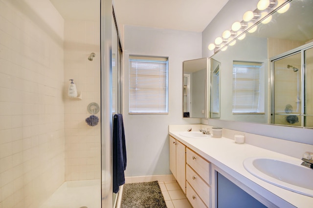 bathroom featuring a shower with door, double sink vanity, and tile flooring