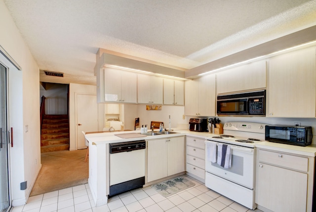 kitchen with light tile floors, white appliances, kitchen peninsula, and sink