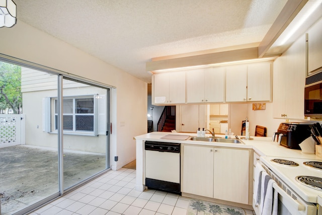 kitchen featuring kitchen peninsula, white appliances, sink, light tile floors, and a textured ceiling