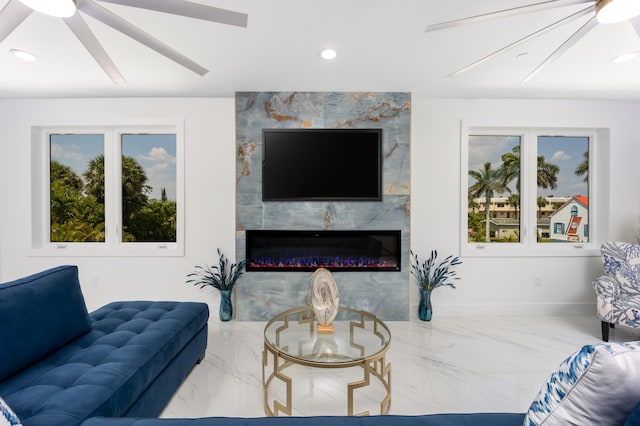 tiled living room with a fireplace, a healthy amount of sunlight, tile walls, and ceiling fan