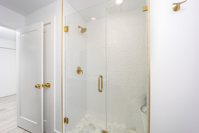 bathroom featuring a shower with door and wood-type flooring