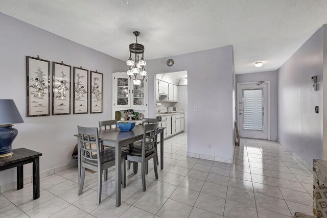 dining area with light tile flooring and a chandelier