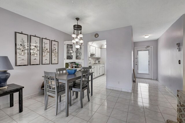 dining space featuring ceiling fan with notable chandelier and light tile floors