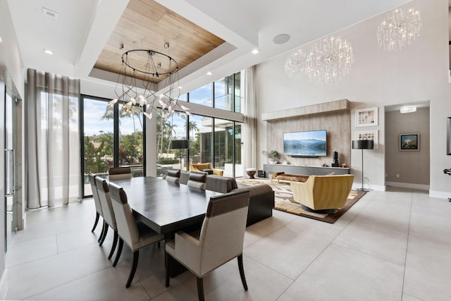 dining room featuring light tile floors, a towering ceiling, a raised ceiling, wooden ceiling, and an inviting chandelier