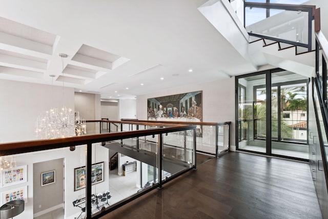 hallway featuring beam ceiling, coffered ceiling, a notable chandelier, and hardwood / wood-style flooring