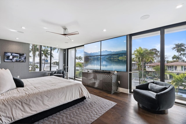 bedroom featuring a water and mountain view, a wall of windows, ceiling fan, and dark hardwood / wood-style floors