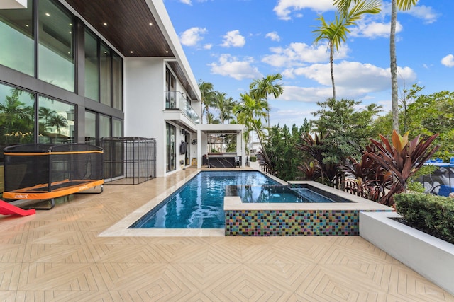 view of swimming pool with a patio and an in ground hot tub