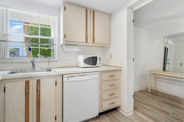 kitchen featuring light brown cabinetry, white appliances, sink, and light wood-type flooring