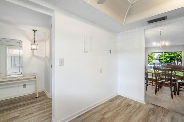 hall with a chandelier and light wood-type flooring