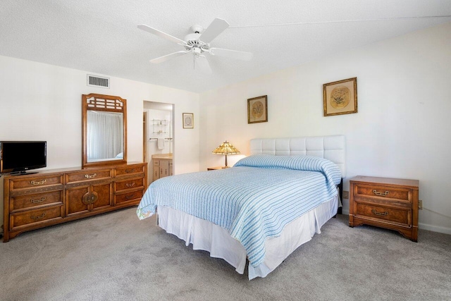 carpeted bedroom featuring connected bathroom, a textured ceiling, and ceiling fan