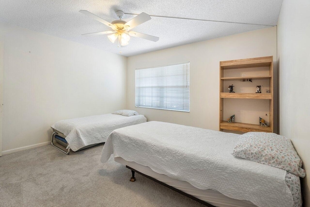 bedroom with a textured ceiling, carpet flooring, and ceiling fan