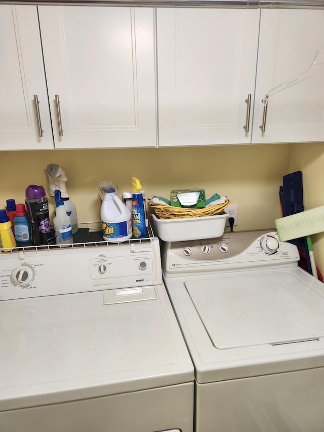 laundry room featuring washing machine and dryer and cabinets