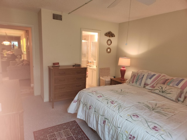 bedroom featuring carpet floors, ensuite bathroom, and ceiling fan