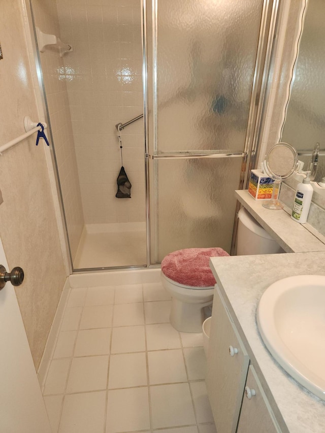 bathroom featuring a shower with door, toilet, tile patterned floors, and vanity