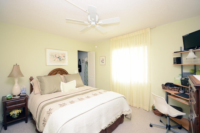 carpeted bedroom with a textured ceiling and ceiling fan