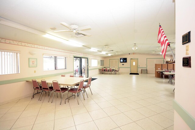 tiled dining room featuring vaulted ceiling and ceiling fan