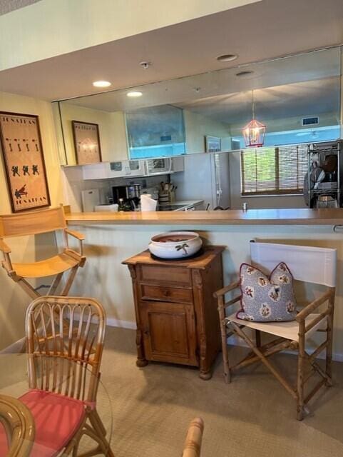 kitchen with pendant lighting and light colored carpet