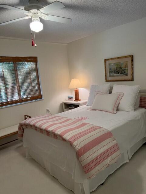 carpeted bedroom with a textured ceiling and ceiling fan