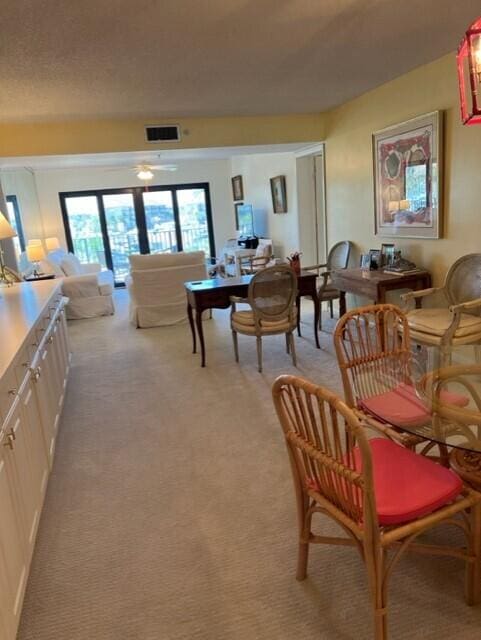 carpeted dining room featuring ceiling fan