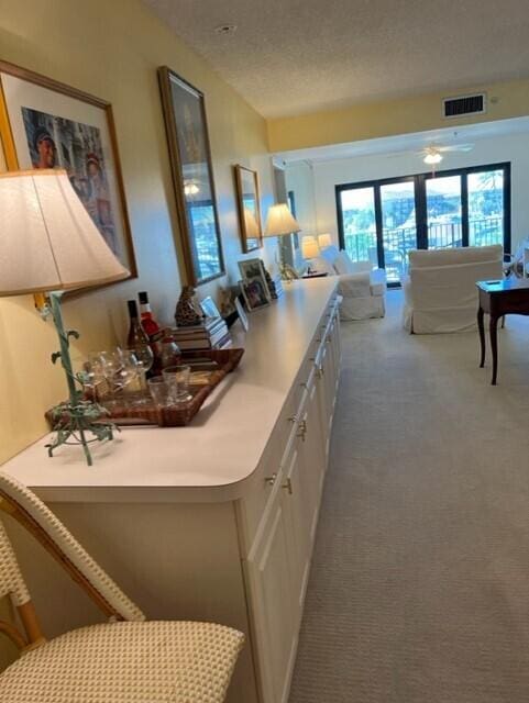 kitchen featuring white cabinetry, ceiling fan, dark carpet, and a textured ceiling