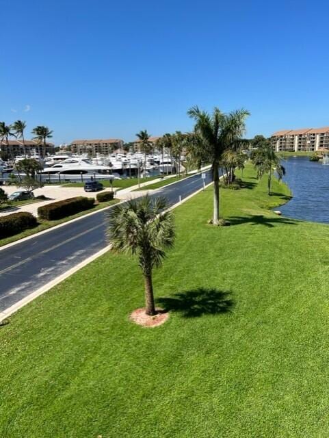 view of home's community with a water view and a yard