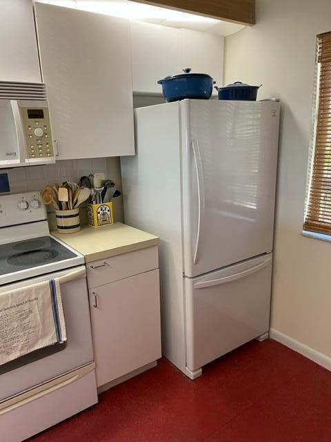 kitchen with white cabinets and white appliances