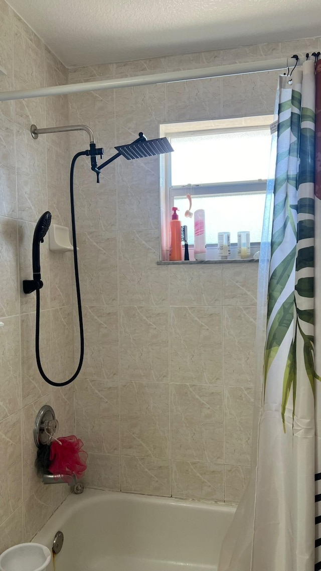 bathroom with shower / tub combo with curtain and a textured ceiling