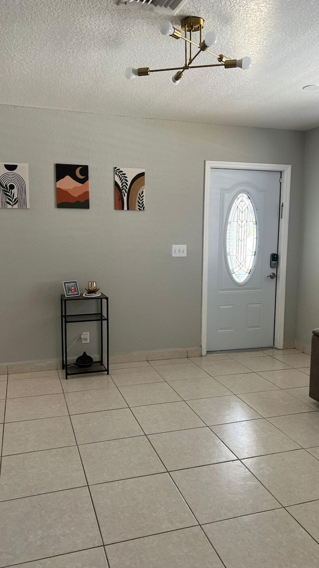 tiled entryway with a textured ceiling