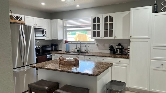 kitchen featuring a breakfast bar, appliances with stainless steel finishes, and white cabinetry