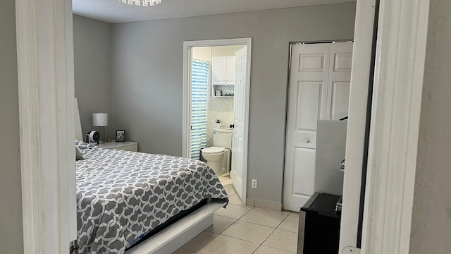 bedroom featuring light tile flooring and ensuite bathroom