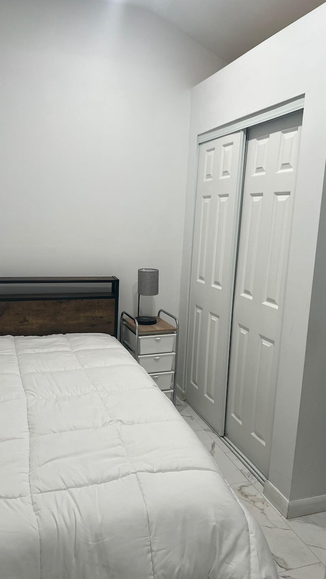 bedroom with a closet and light tile floors