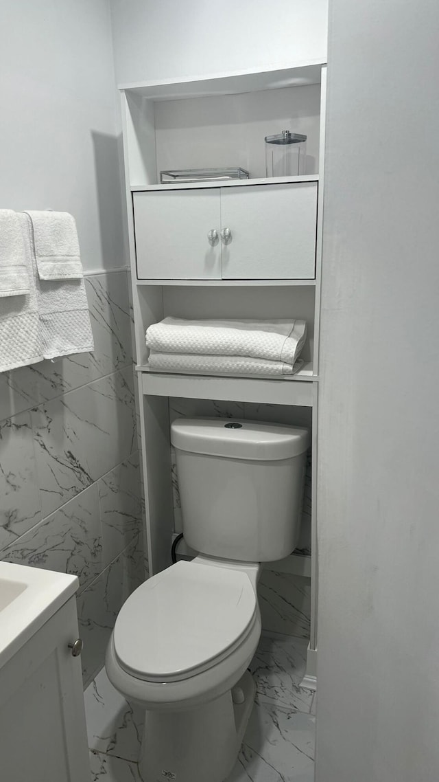 bathroom with toilet, tile floors, and vanity