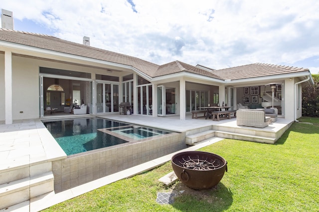 view of pool with an outdoor living space, an in ground hot tub, a lawn, and a patio