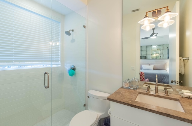 bathroom with oversized vanity, toilet, ceiling fan, and a shower with door