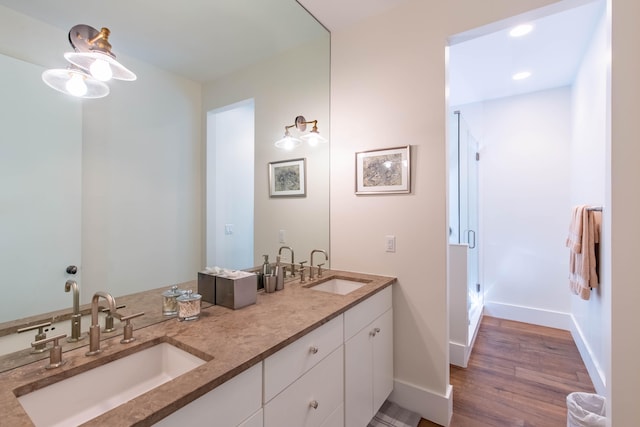 bathroom with dual vanity and wood-type flooring