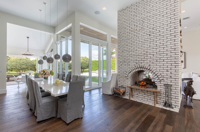 dining space with plenty of natural light, dark hardwood / wood-style floors, and a brick fireplace