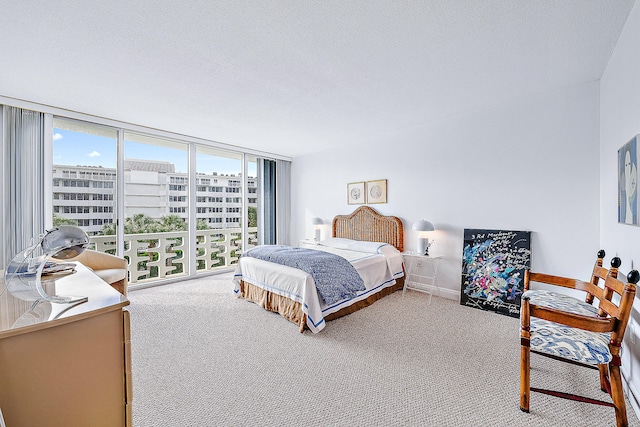 carpeted bedroom with expansive windows and a textured ceiling