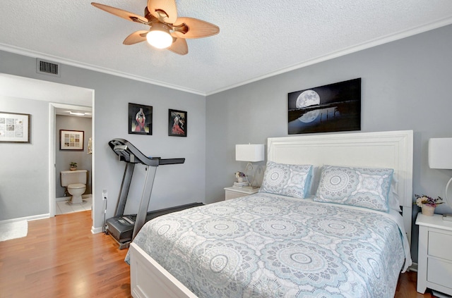 bedroom featuring a textured ceiling, ceiling fan, visible vents, light wood-type flooring, and crown molding