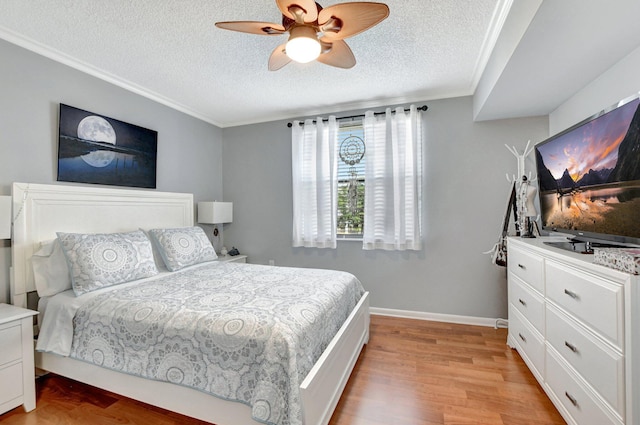 bedroom featuring light wood-style flooring, crown molding, baseboards, and a textured ceiling