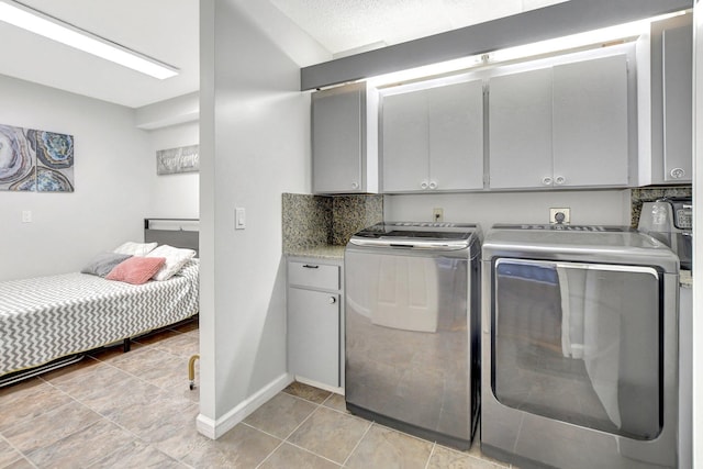 laundry room featuring cabinet space, washer and clothes dryer, and baseboards