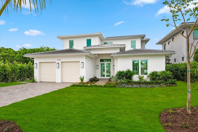 view of front facade with a front yard, french doors, and a garage