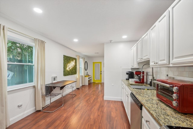 kitchen with backsplash, dark hardwood / wood-style floors, white cabinetry, and stainless steel dishwasher