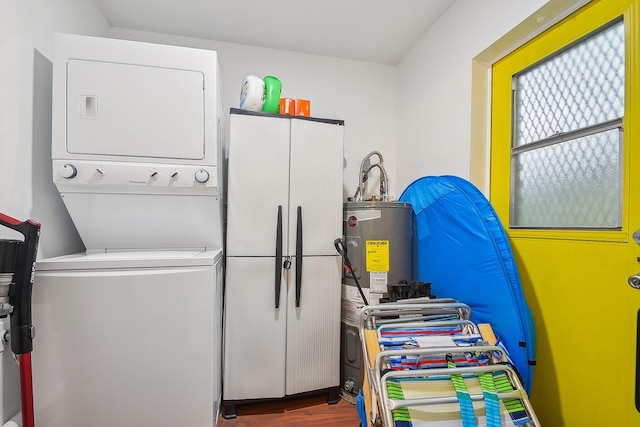 laundry area with cabinets, stacked washing maching and dryer, and wood-type flooring