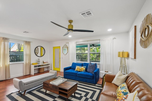 living room featuring dark wood-type flooring and ceiling fan