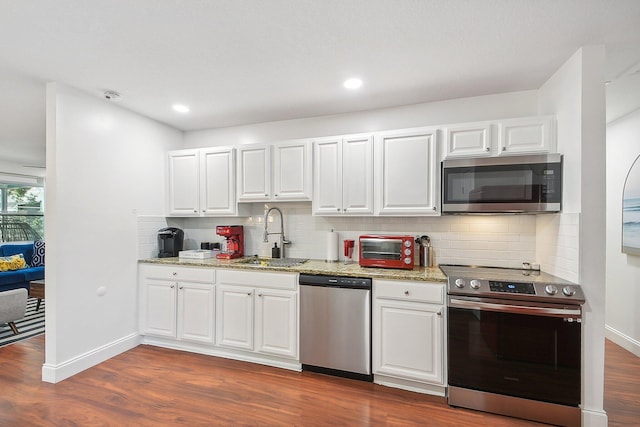 kitchen featuring white cabinets, backsplash, stainless steel appliances, and dark hardwood / wood-style flooring